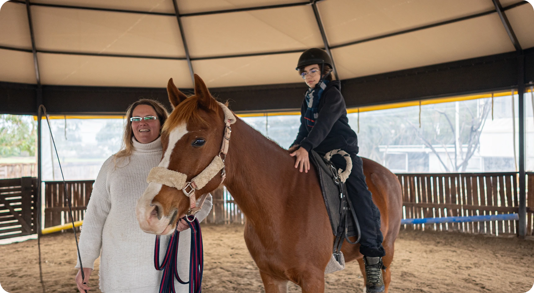 Child riding horse indoors