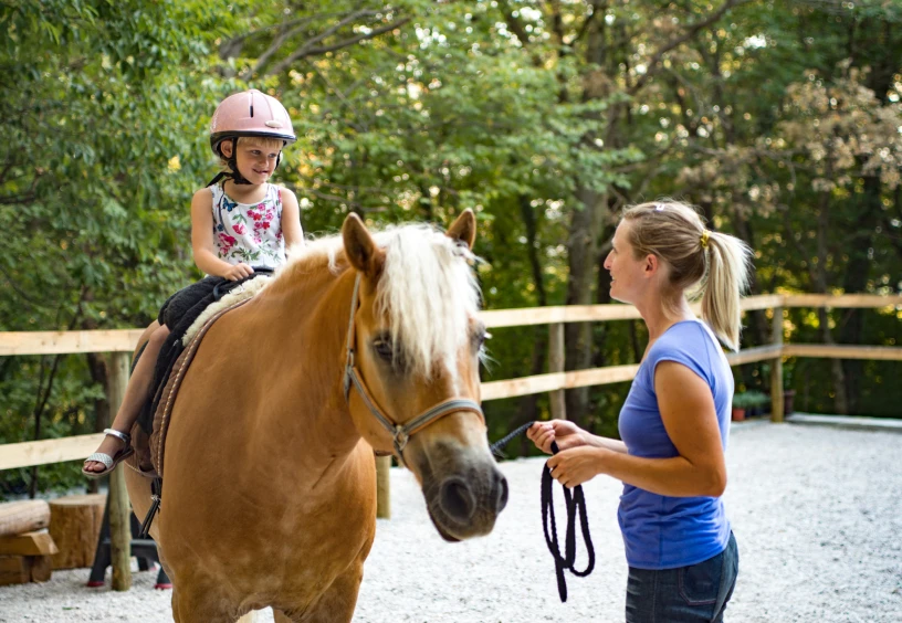 Equestrian lesson for young child outdoors